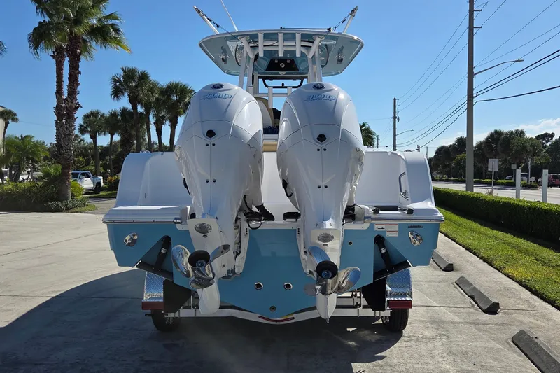 Slide: The Image of 2022 Sportsman Open 282TE Center Console with dual outboard engines, parked outdoors. - 3