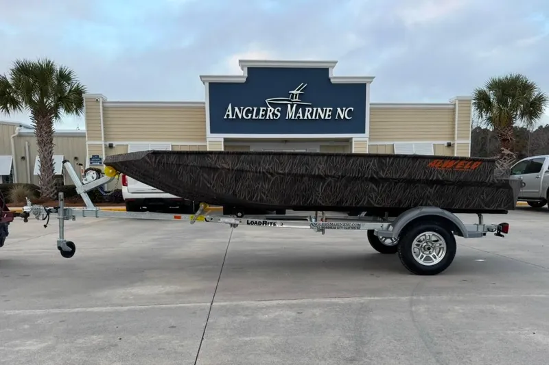Slide: The Image of 2026 Alweld 1548VV Marsh boat with Yamaha motor on trailer, parked outside a building. - 1