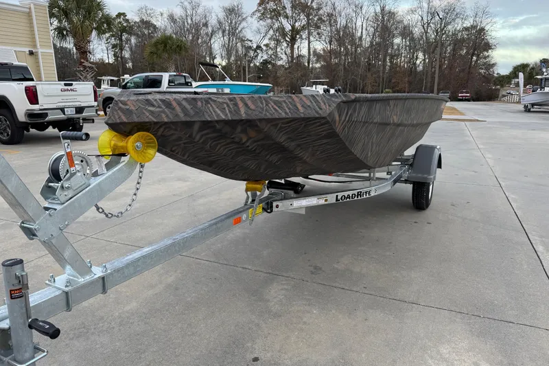 Slide: The Image of 2026 Alweld 1548VV Marsh boat with Yamaha 25 outboard motor, parked outdoors. - 2