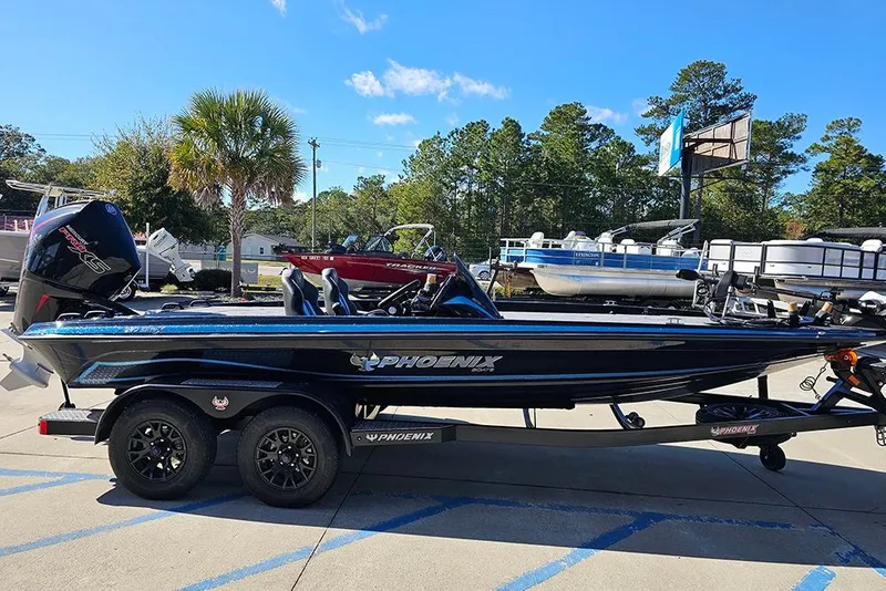 Slide: The Image of 2026 Phoenix 920 Elite X boat on trailer, parked outdoors under clear sky. - 6