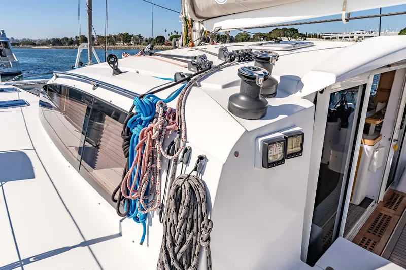 Slide: The Image of 2014 Outremer 51 sailboat deck with ropes and winches, docked by the water. - 12