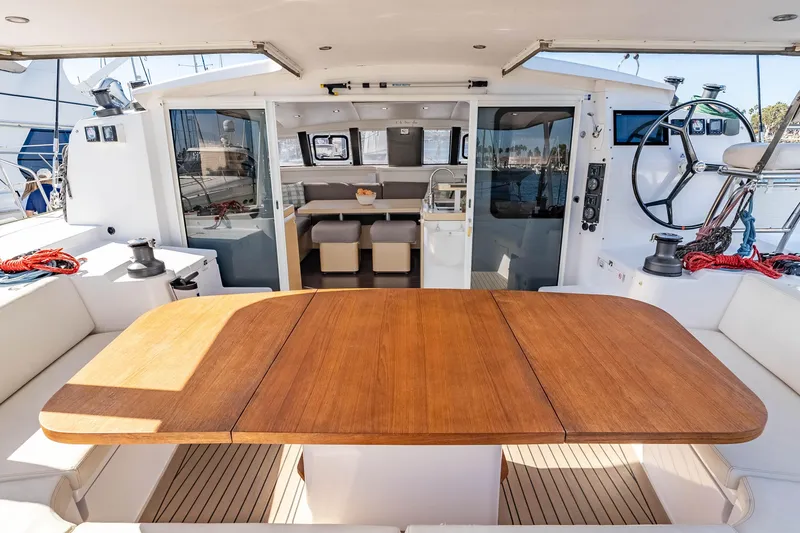 Slide: The Image of 2014 Outremer 51 yacht cockpit with wooden table, helm, and spacious seating area. - 14