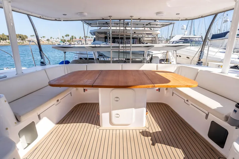 Slide: The Image of Spacious deck of 2014 Outremer 51 catamaran with wooden table and white seating. - 15