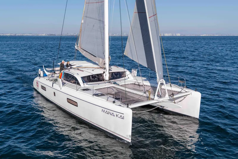 Slide: The Image of 2014 Outremer 51 catamaran sailing on open sea under clear skies. - 2