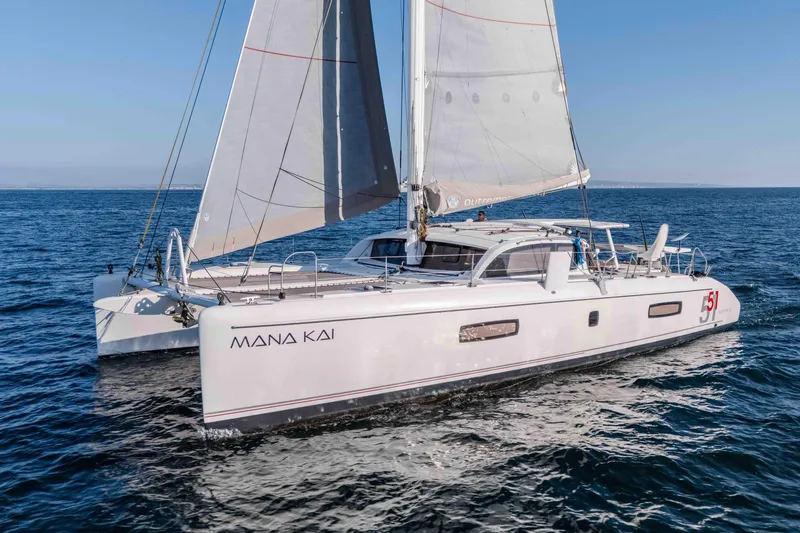 Slide: The Image of 2014 Outremer 51 catamaran sailing on open sea, named "Mana Kai". - 7