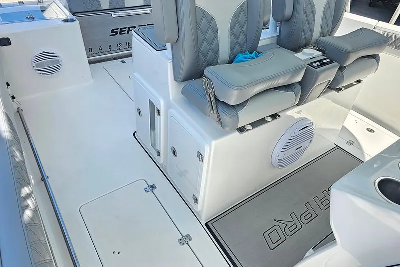 Slide: The Image of 2026 Sea Pro 322 Offshore boat interior with gray seating and storage compartments. - 21