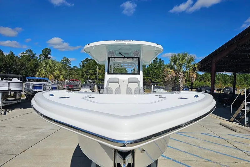 Slide: The Image of 2026 Sea Pro 322 Offshore boat in marina, clear sky, surrounded by trees and other boats. - 4