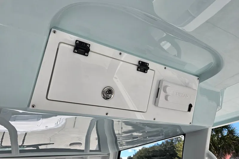 Slide: The Image of 2026 Sea Pro 322 Offshore boat interior storage compartment and Simrad electronics. - 56