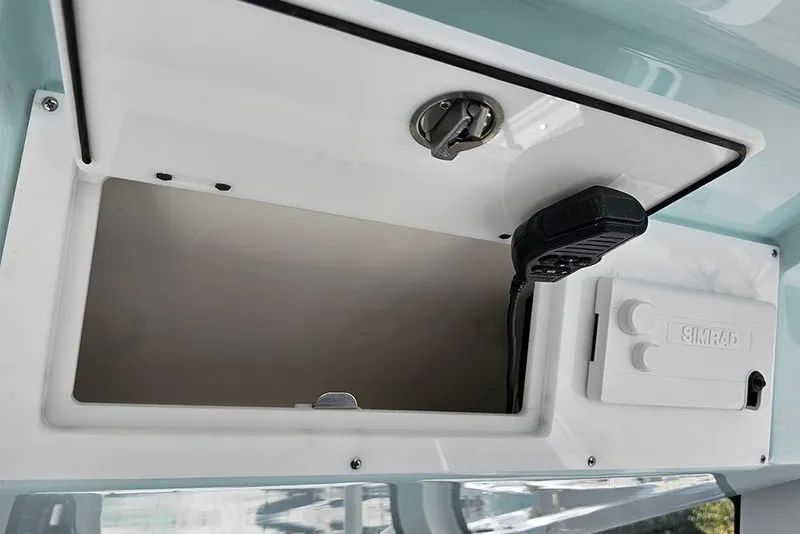 Slide: The Image of 2026 Sea Pro 322 Offshore boat storage compartment with Simrad electronics and radio. - 57