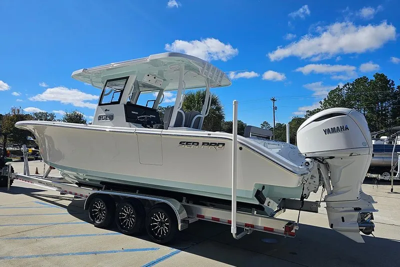 Slide: The Image of 2026 Sea Pro 322 Offshore boat on trailer with Yamaha engine, under clear blue sky. - 7