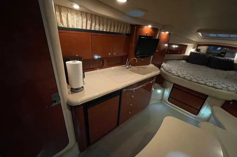 Slide: The Image of 2003 Sea Ray 340 Sundancer interior with kitchenette, bed, and wood cabinetry. - 17