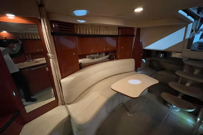 Slide: The Image of Interior of 2003 Sea Ray 340 Sundancer yacht with elegant seating and wooden cabinetry. - 19