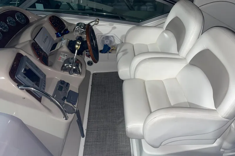Slide: The Image of 2003 Sea Ray 340 Sundancer helm with white leather seats and navigation controls. - 2