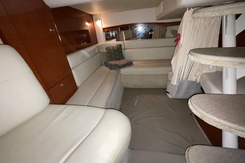 Slide: The Image of 2003 Sea Ray 340 Sundancer cabin interior with white seating and wooden accents. - 20