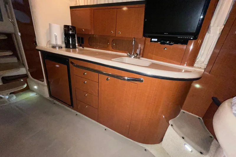 Slide: The Image of 2003 Sea Ray 340 Sundancer interior kitchen with wood cabinetry and modern appliances. - 22