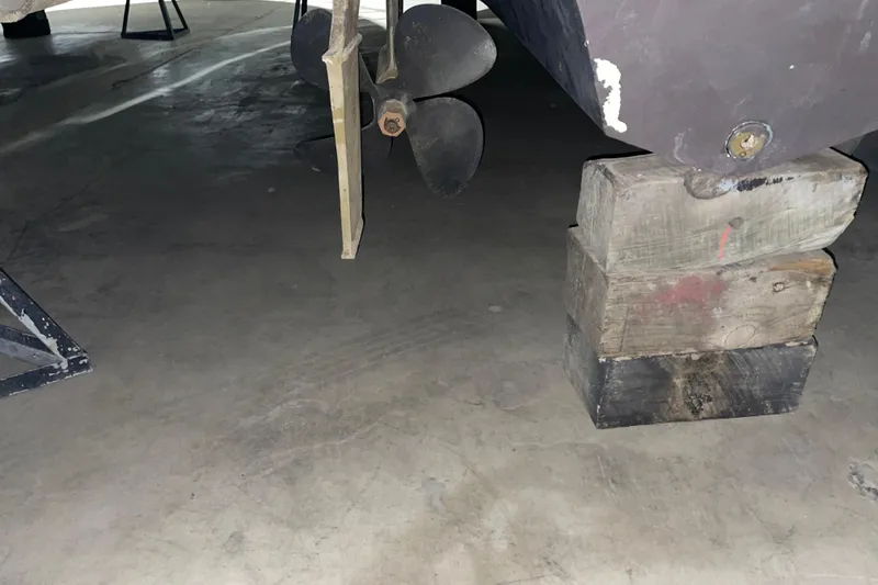 Slide: The Image of 2003 Sea Ray 340 Sundancer propeller and hull on wooden blocks in storage. - 25