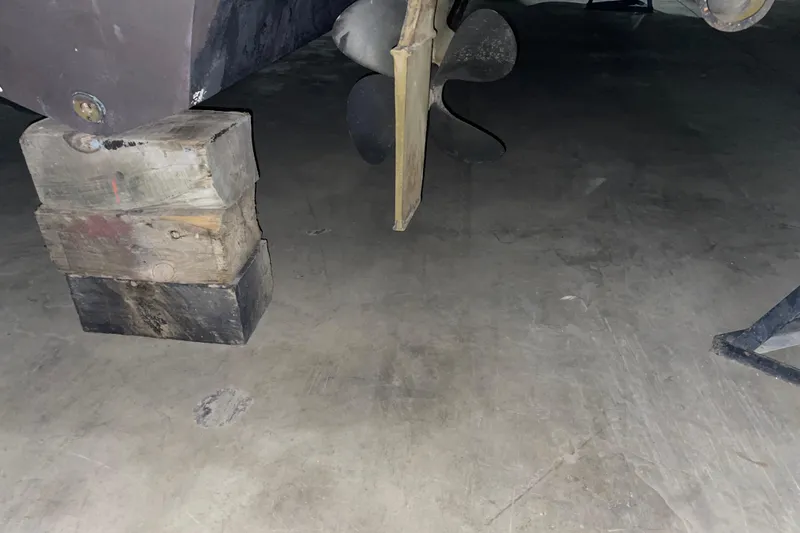 Slide: The Image of 2003 Sea Ray 340 Sundancer propeller and hull supported by wooden blocks. - 26