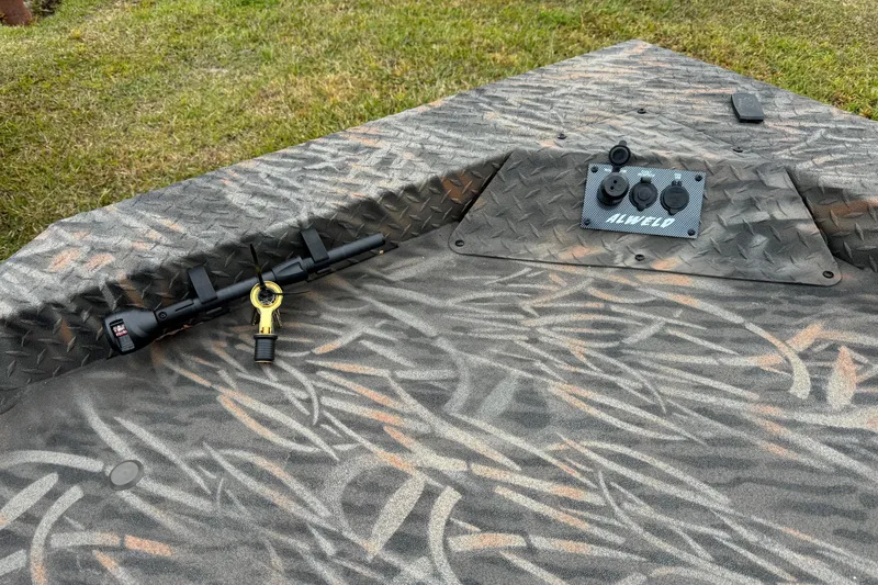 Slide: The Image of 2026 Alweld 1652 VV Invader boat deck with camo pattern and control panel. - 11