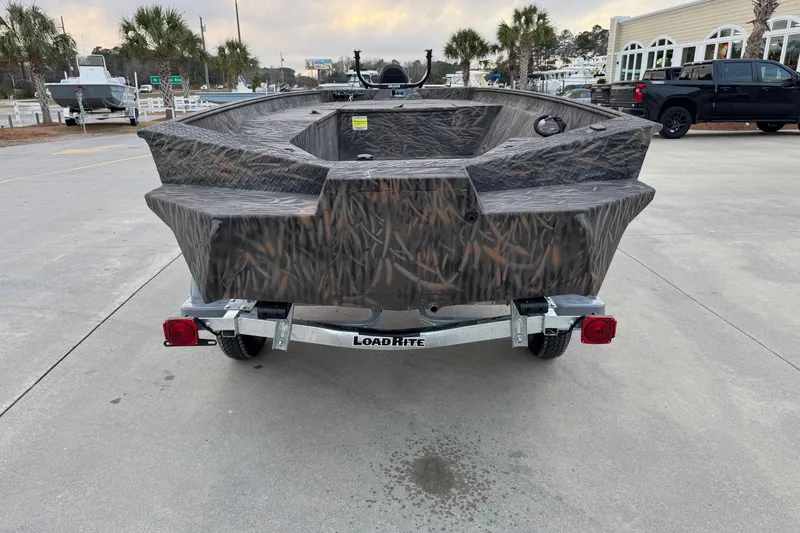 Slide: The Image of 2026 Alweld 1652 VV Invader boat on Load Rite trailer, camo design, parked outdoors. - 3