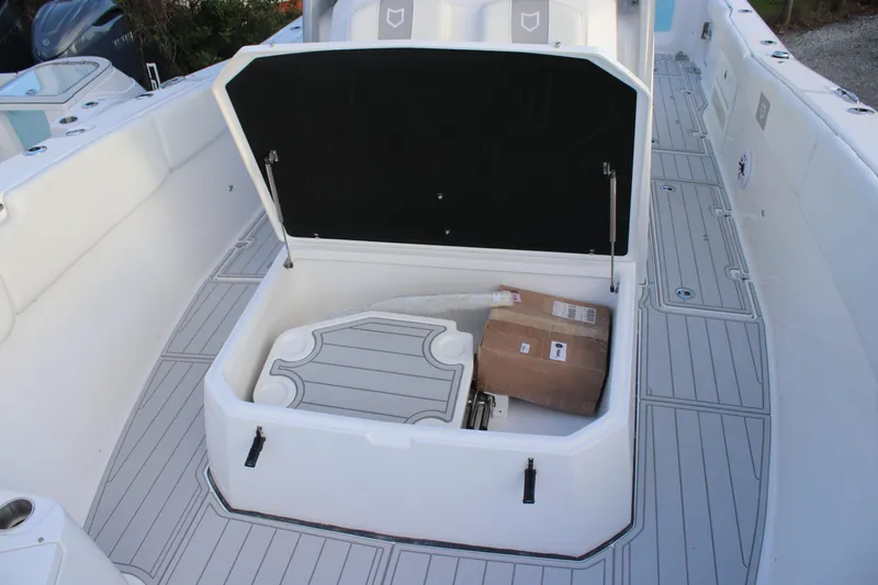 Slide: The Image of 2026 Sea Fox 328 Commander boat storage compartment open with packages inside. - 13
