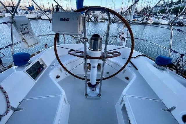 Slide: The Image of 2003 Sabre 426 sailboat with vibrant orange sail docked in marina under clear blue sky. - 13