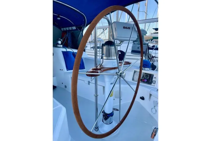 Slide: The Image of 2003 Sabre 426 sailboat docked, featuring a blue sail cover and marina background. - 14