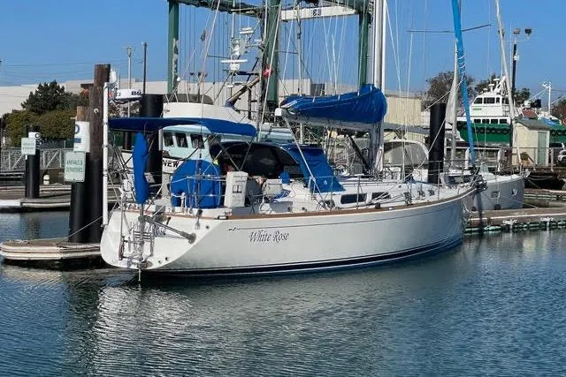 Slide: The Image of 2004 Sabre 426 sailboat docked in a marina, clear blue sky background. - 2