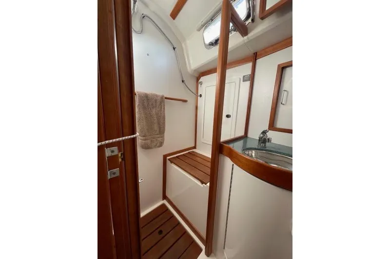 Slide: The Image of Interior of 2004 Sabre 426 sailboat with wooden cabinetry and green cushioned seating. - 31