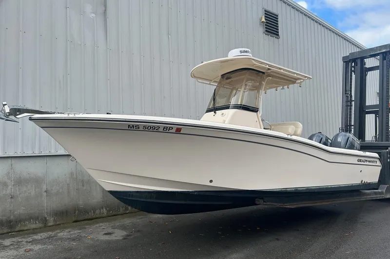 The Image of 2021 Grady-White Fisherman 257 boat on trailer, parked near a metal building. - 0