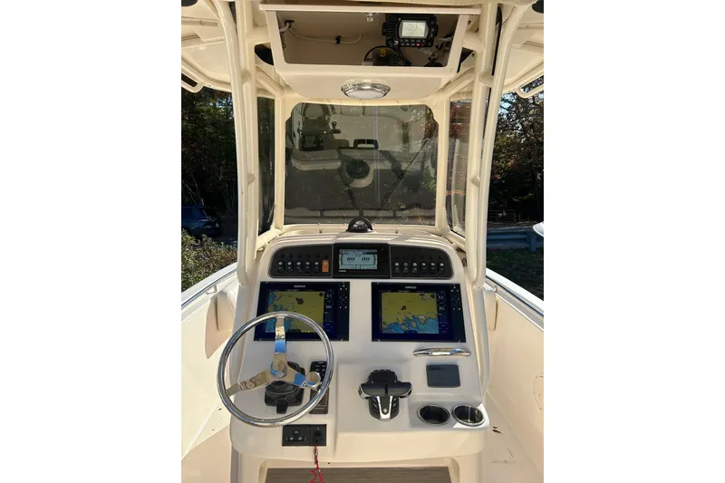Slide: The Image of 2021 Grady-White Fisherman 257 boat dashboard with navigation screens and steering wheel. - 3