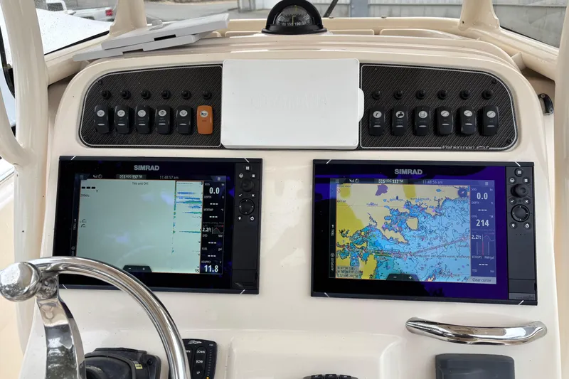 Slide: The Image of 2021 Grady-White Fisherman 257 dashboard with dual Simrad displays and control panel. - 4