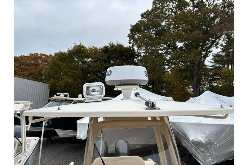 Slide: The Image of 2021 Grady-White Fisherman 257 boat with radar and spotlight, surrounded by trees and other boats. - 8
