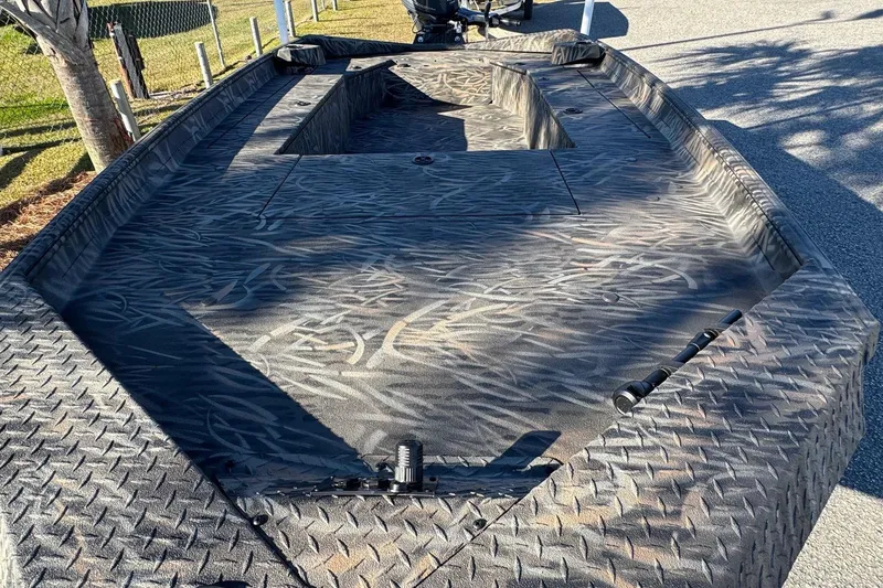 Slide: The Image of 2026 Alweld 1756 Invader boat with textured deck, parked outdoors. - 11