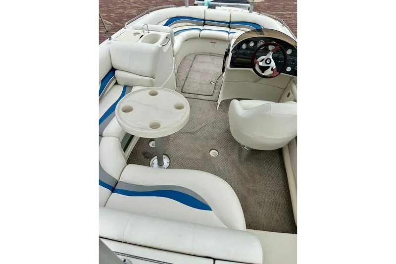 Slide: The Image of 2004 Bennington RL 210 boat interior with seating, table, and steering console. - 16