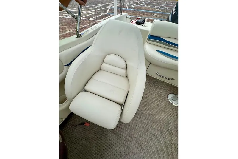Slide: The Image of White leather seat on 2004 Bennington RL 210 boat, featuring blue accents and textured flooring. - 19