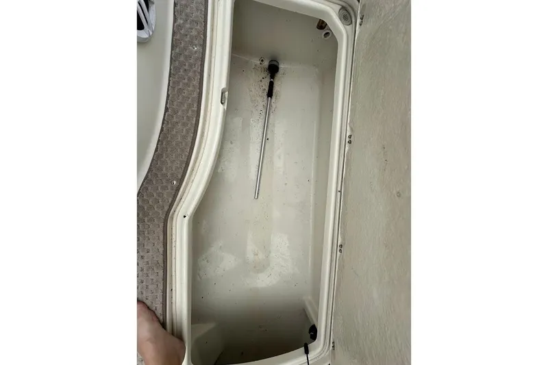 Slide: The Image of Storage compartment in a 2004 Bennington RL 210 boat, featuring a clean interior. - 30