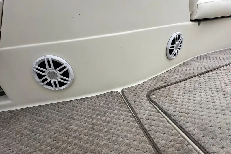 Slide: The Image of 2004 Bennington RL 210 boat interior with speakers and carpeted flooring. - 32