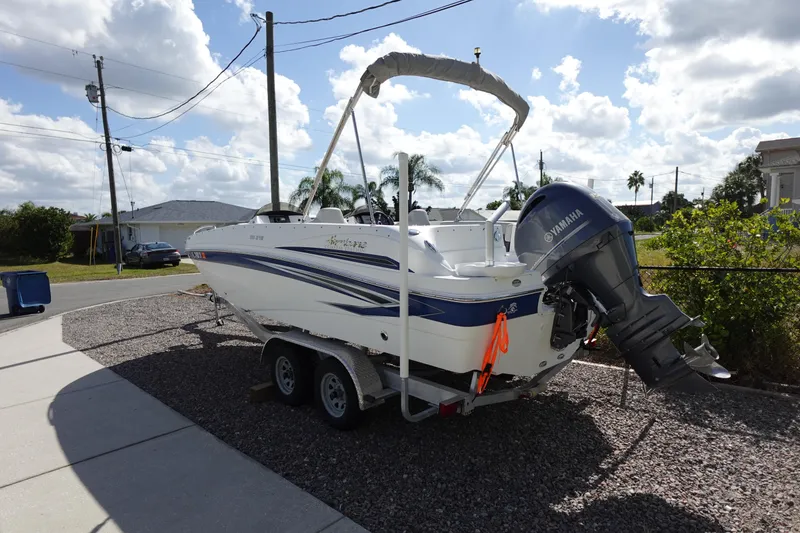 Slide: The Image of 2021 Hurricane Sundeck Sport 218 OB boat on trailer, parked in a residential driveway. - 12