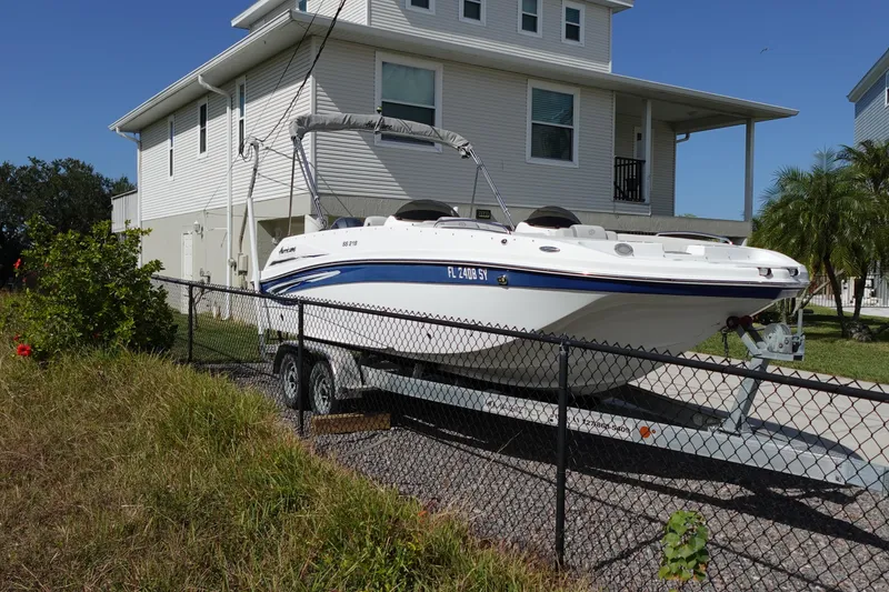 Slide: The Image of 2021 Hurricane Sundeck Sport 218 OB boat on trailer beside a house. - 4