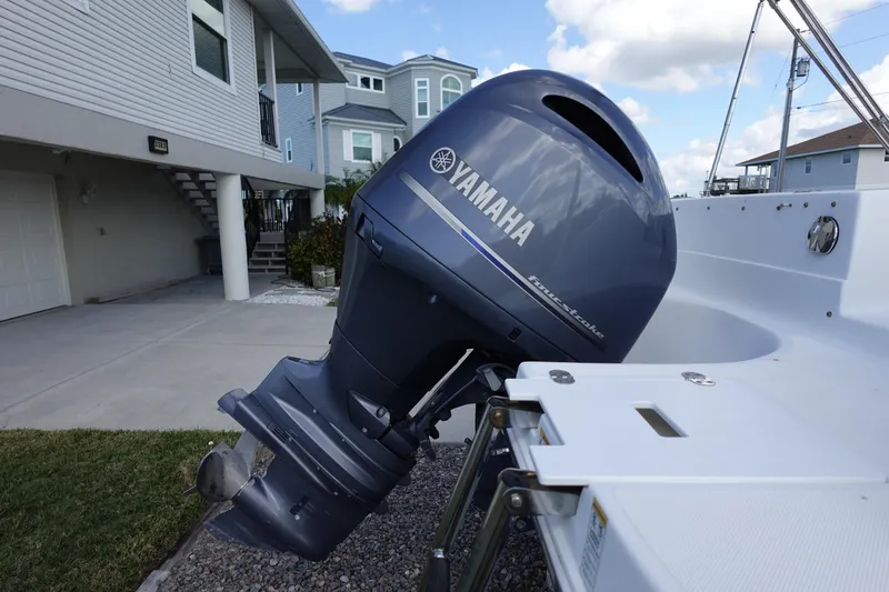Slide: The Image of 2021 Hurricane Sundeck Sport 218 OB with Yamaha outboard motor, parked near modern house. - 59