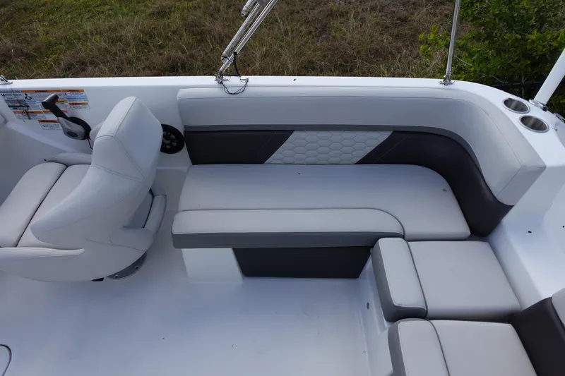 Slide: The Image of 2021 Hurricane Sundeck Sport 218 OB boat interior with cushioned seating and steering area. - 64