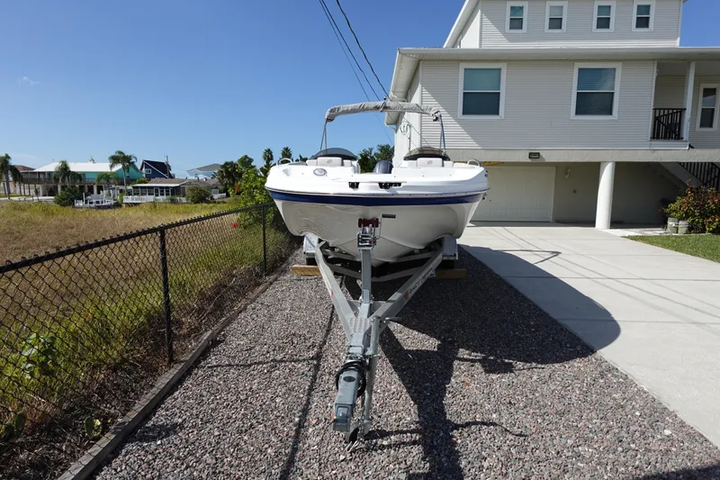Slide: The Image of 2021 Hurricane Sundeck Sport 218 OB boat on trailer beside a house. - 77