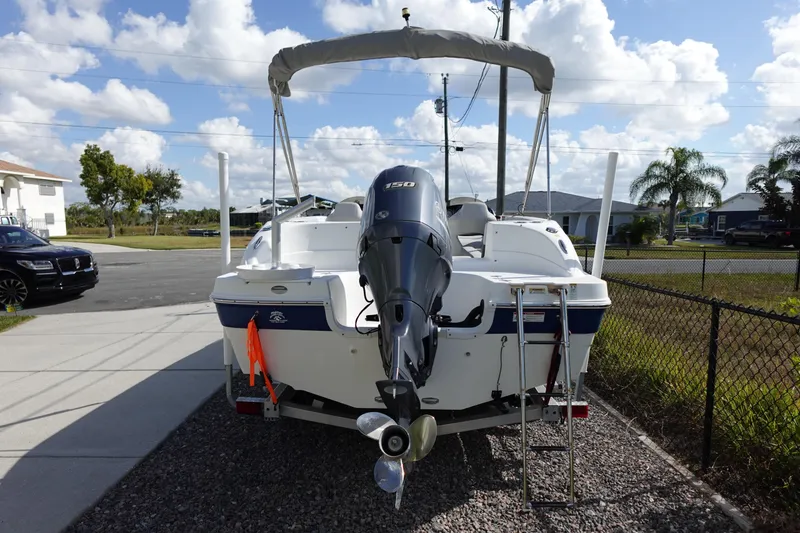 Slide: The Image of 2021 Hurricane Sundeck Sport 218 OB boat with outboard motor, parked in driveway. - 81