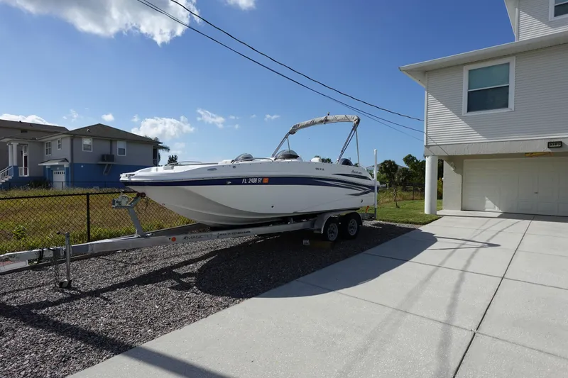 Slide: The Image of 2021 Hurricane Sundeck Sport 218 OB boat on trailer beside house. - 84