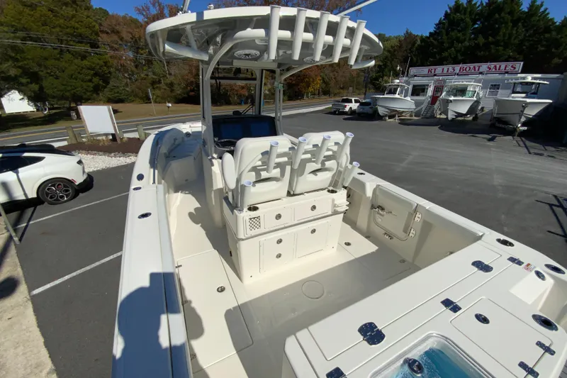 Slide: The Image of 2026 Cobia 265 Center Console boat at dealership, showcasing spacious deck and seating. - 10