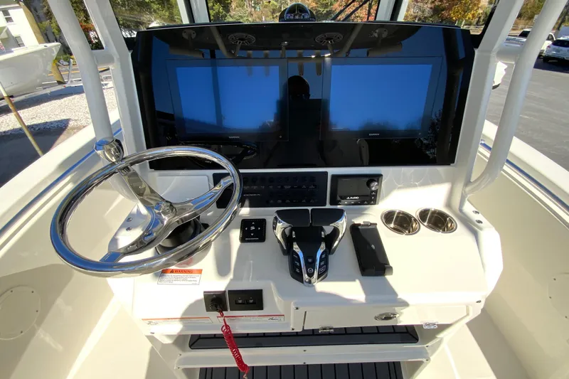 Slide: The Image of 2026 Cobia 265 Center Console boat dashboard with steering wheel and dual screens. - 12