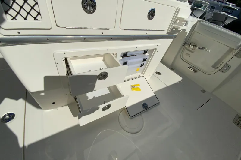Slide: The Image of 2026 Cobia 265 Center Console boat storage compartments with open drawers and tackle storage. - 20