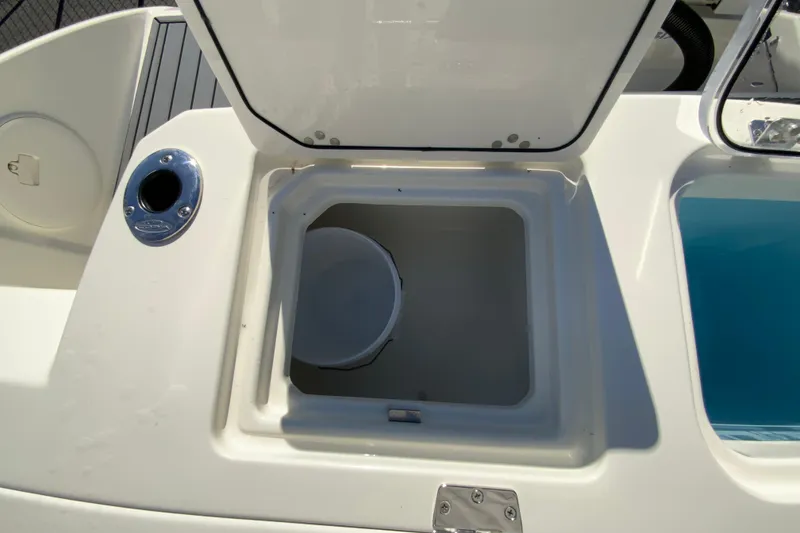 Slide: The Image of 2026 Cobia 265 Center Console boat storage compartment with open lid. - 24