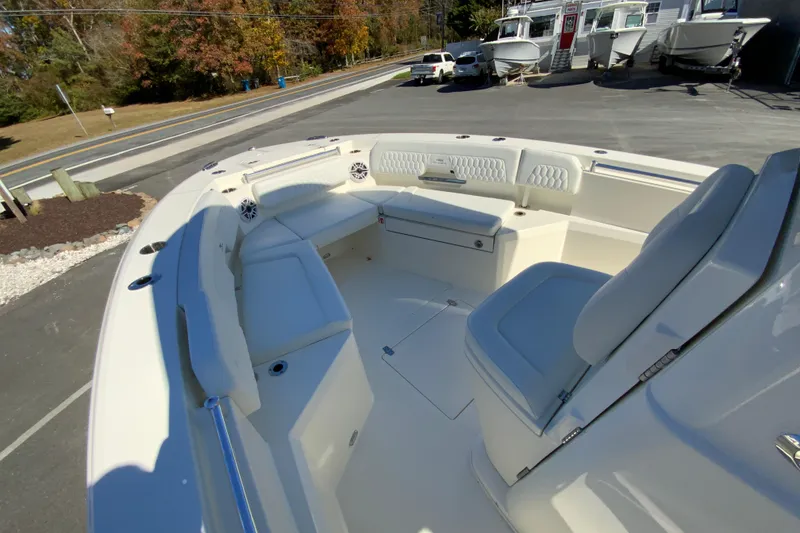 Slide: The Image of 2026 Cobia 265 Center Console boat interior with seating and storage, parked outdoors. - 28
