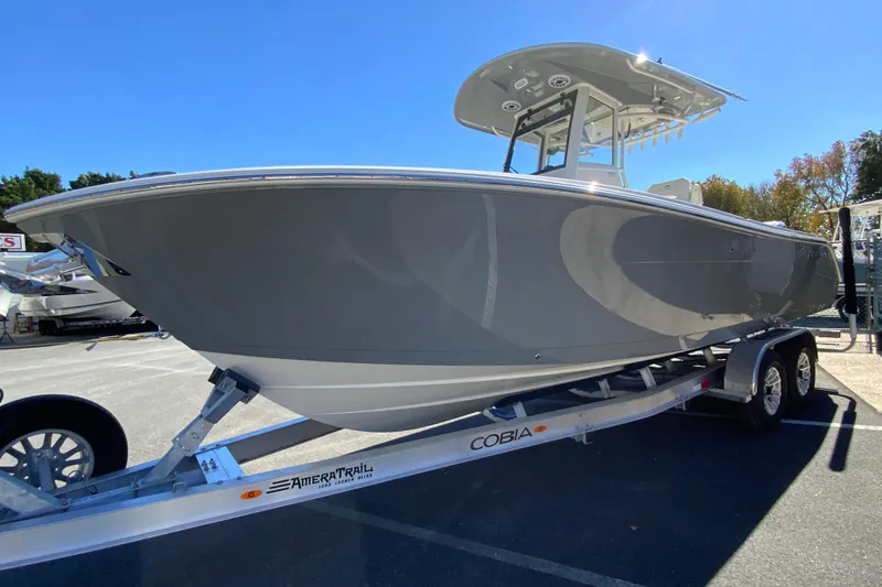 Slide: The Image of 2026 Cobia 265 Center Console boat on trailer under clear blue sky. - 5